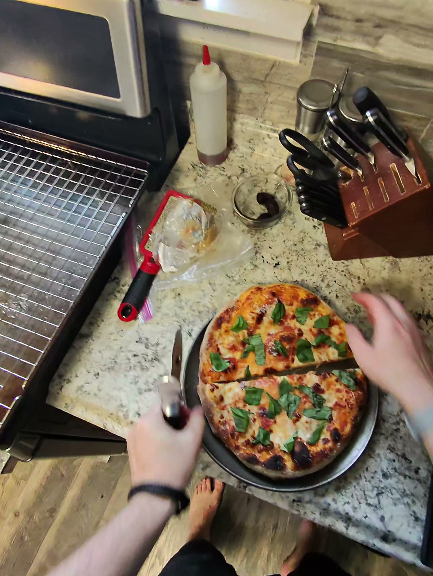 Same-day dough margherita pizza on a metal pan with fresh basil leaves on top and a leoparded, blistered crust around the edges, baked at 550 degrees on a pizza stone